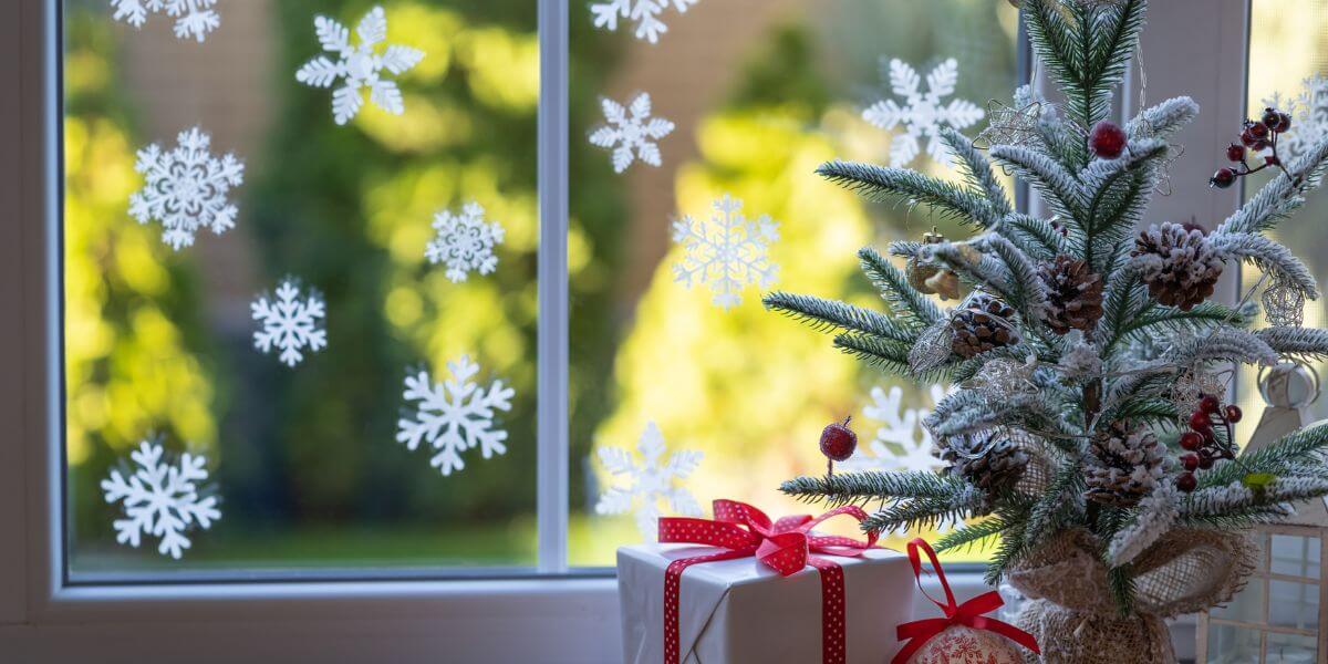 Festive Christmas Window Decor: Christmas Tree Decorations on the Window Sill and Snowflake Window Clings
